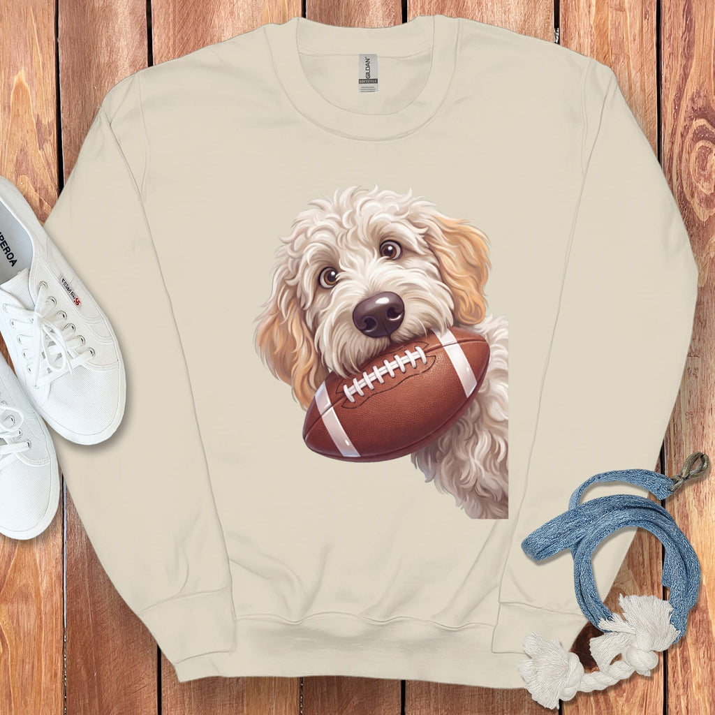 Cream sweatshirt with a goldendoodle holding a football design.