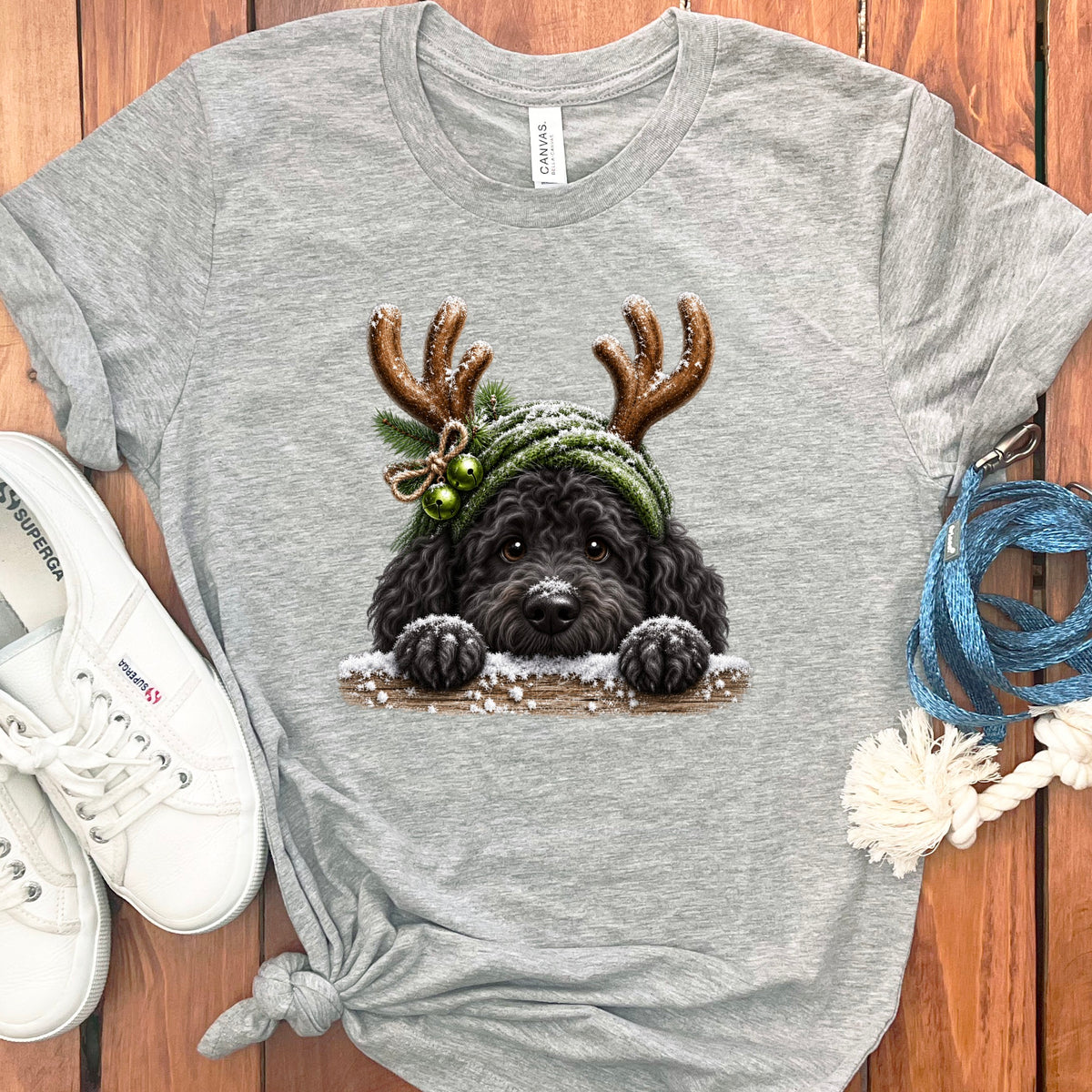 Grey t-shirt with a black dog wearing antlers and a green hat with bells.