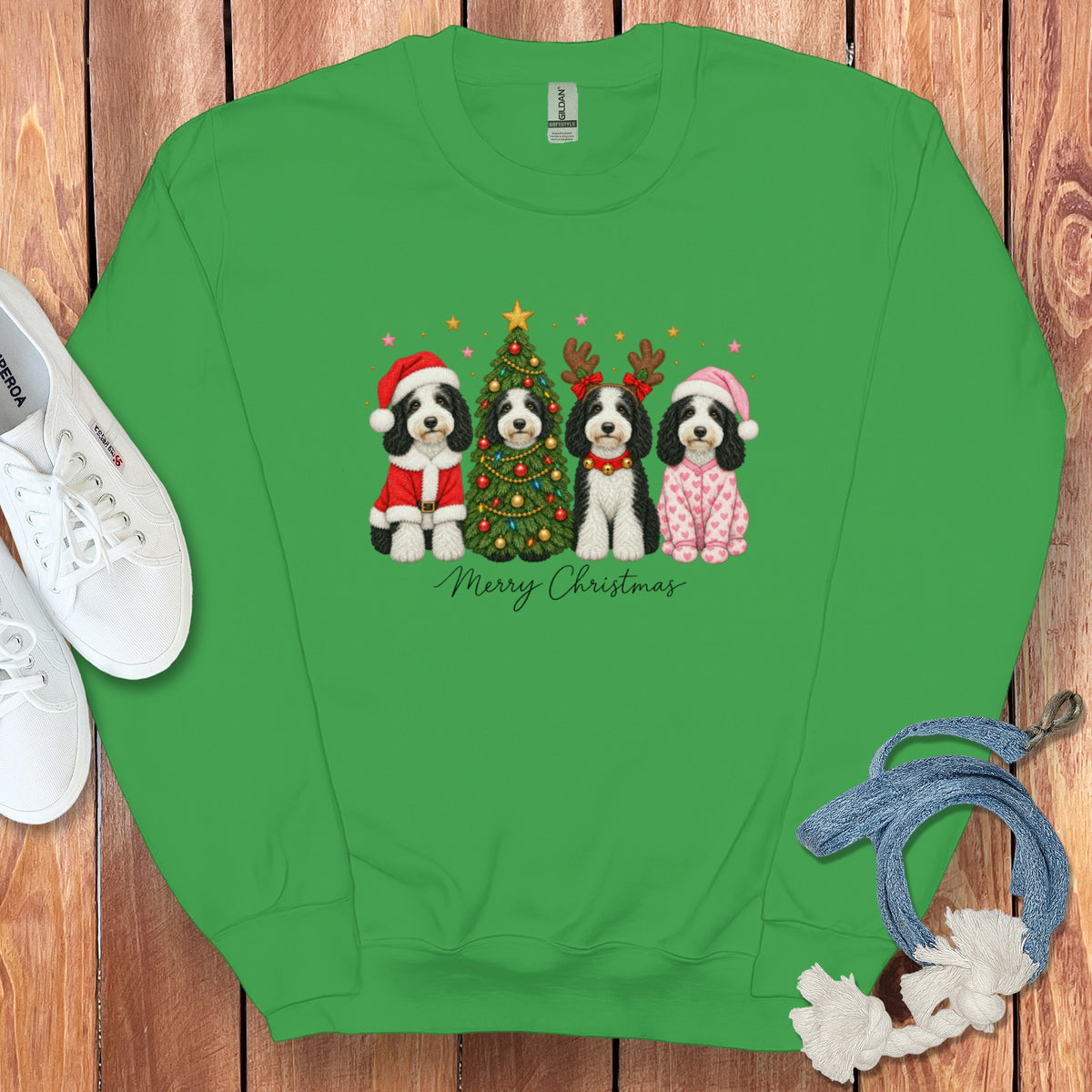 A green crewneck sweatshirt featuring a graphic of four dogs in holiday costumes and a Christmas tree with the text "Merry Christmas".