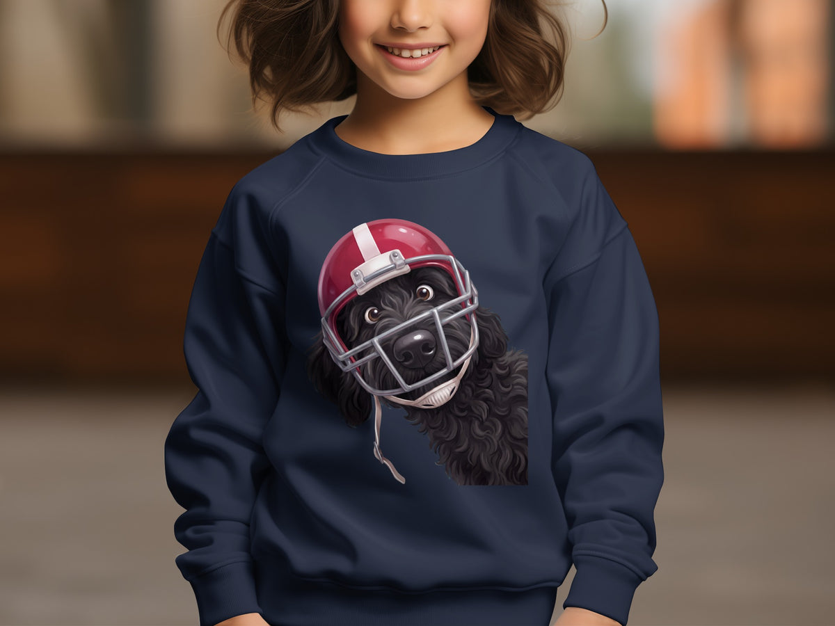Black poodle wearing a red football helmet on a navy blue sweatshirt.