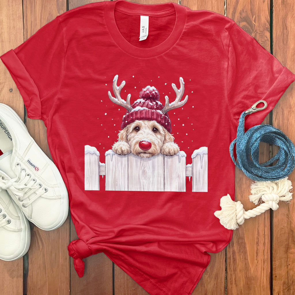Red t-shirt with a cartoon doodle wearing a Santa hat and antlers peeking over a fence.