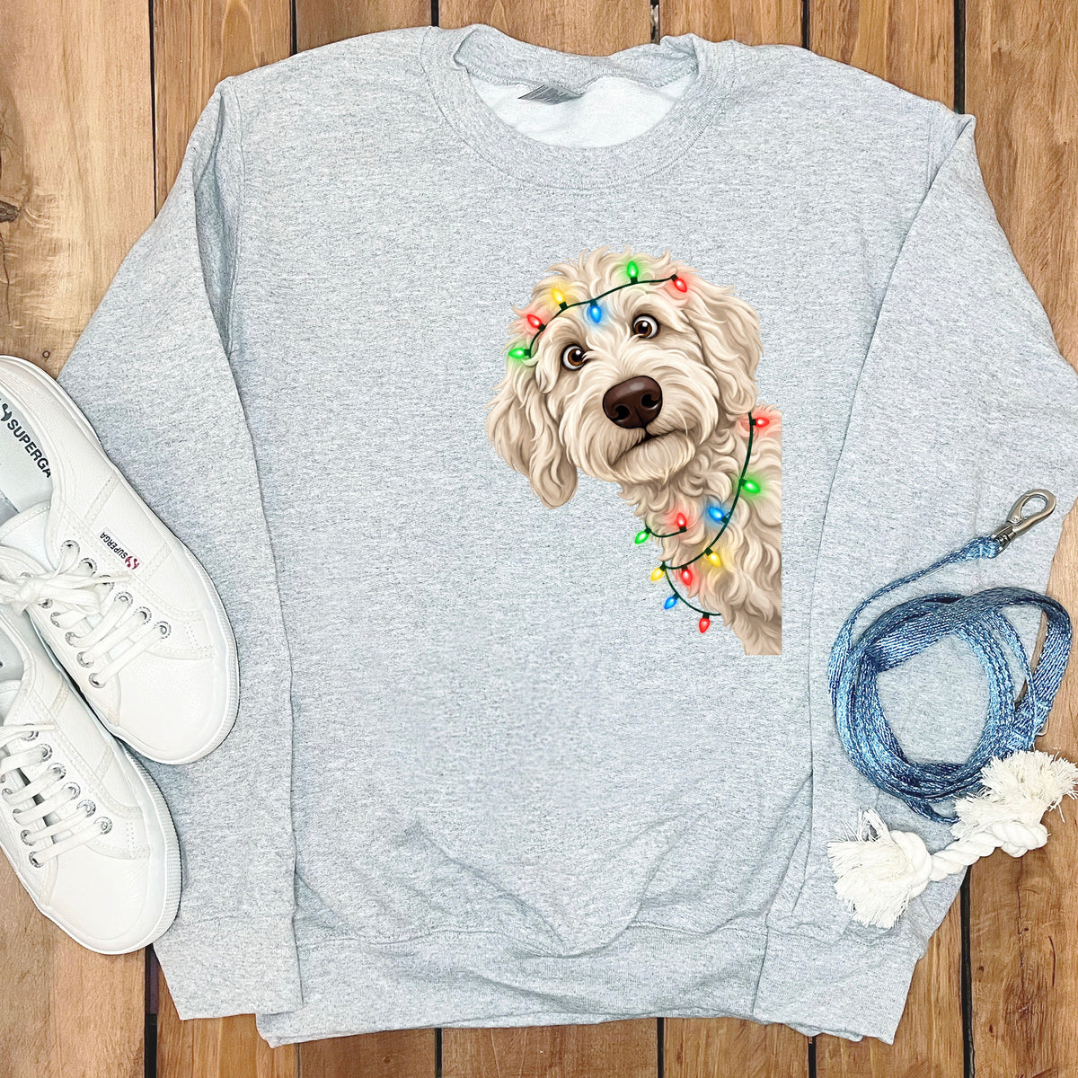 Light gray sweatshirt with a doodle dog wearing colorful Christmas lights.