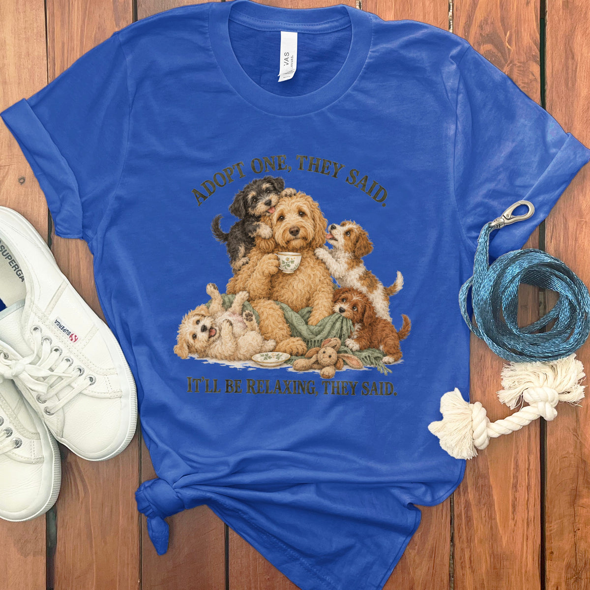 Blue t-shirt with dogs drinking tea and text "Adopt one, they said. It'll be relaxing, they said."