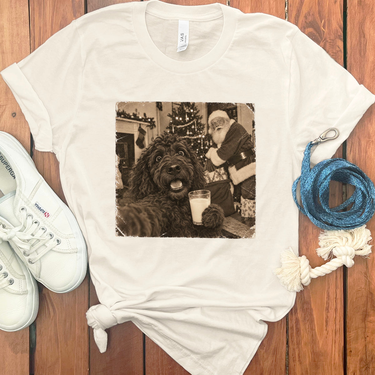 Cream t-shirt featuring a vintage sepia graphic of a dog holding a glass of milk with Santa Claus in the background.