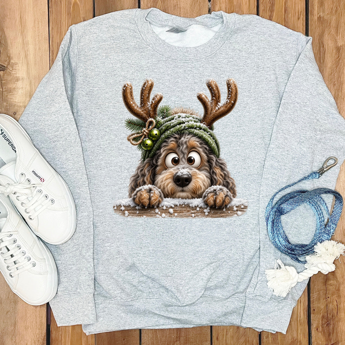 Grey sweatshirt with a cartoon dog wearing reindeer antlers and a knitted hat.