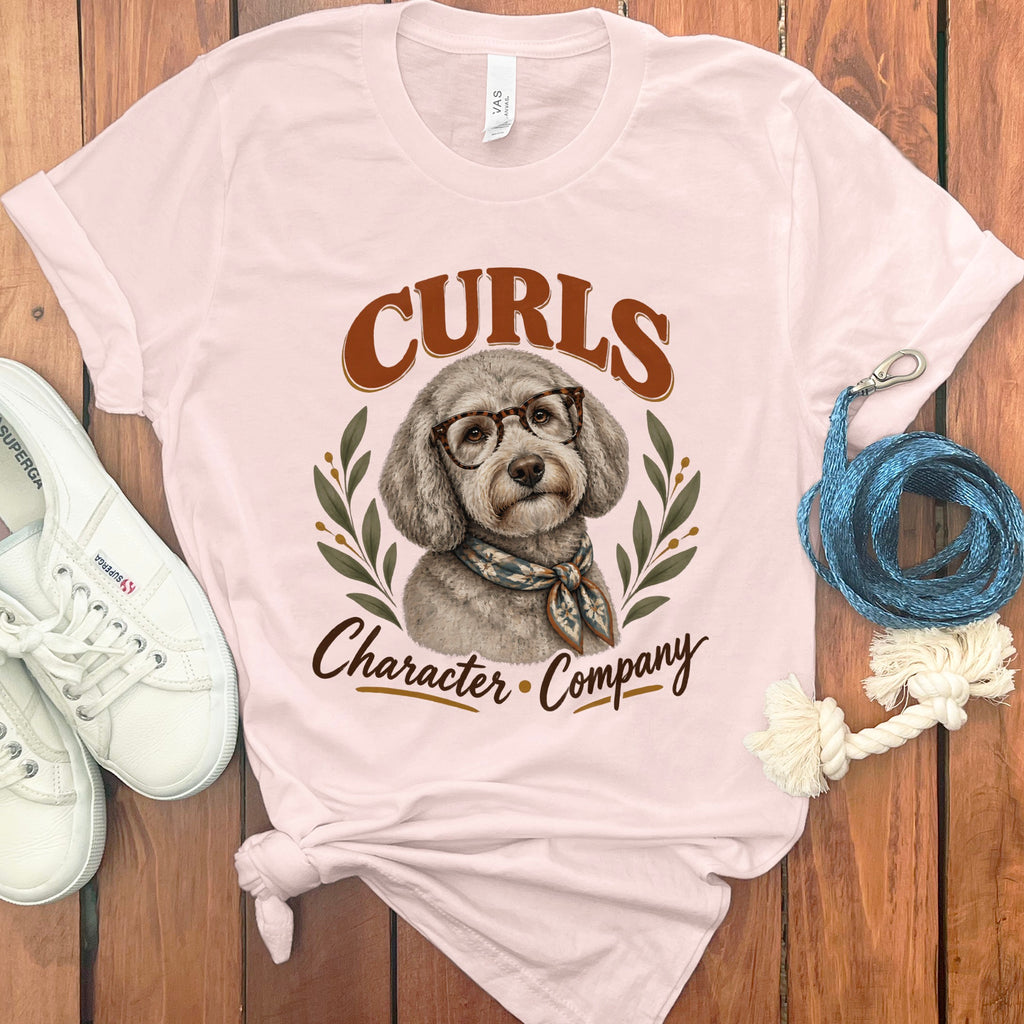 Light pink t-shirt with a poodle graphic and the text "Curls Character Company".