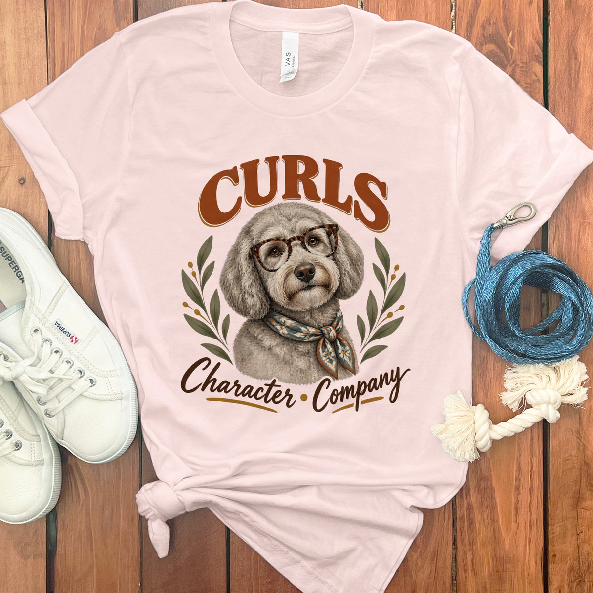 Light pink t-shirt with a poodle graphic and the text "Curls Character Company".