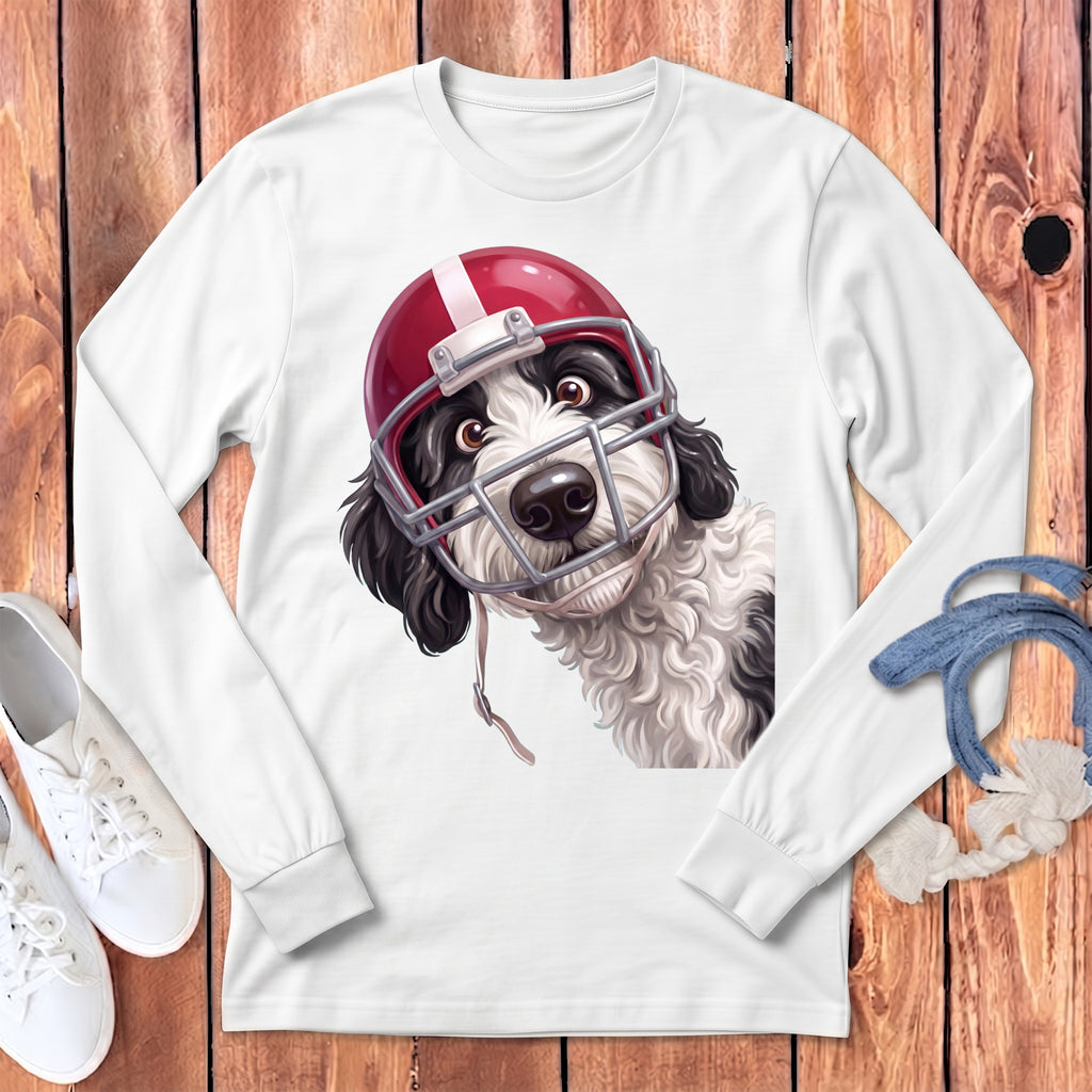 Dog wearing a red and white football helmet on a white long-sleeved shirt.