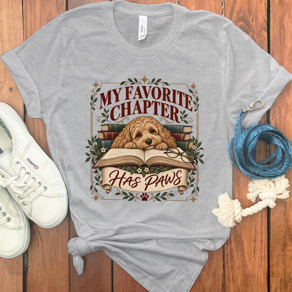 Grey t-shirt graphic with a dog on a book, text "My Favorite Chapter Has Paws."