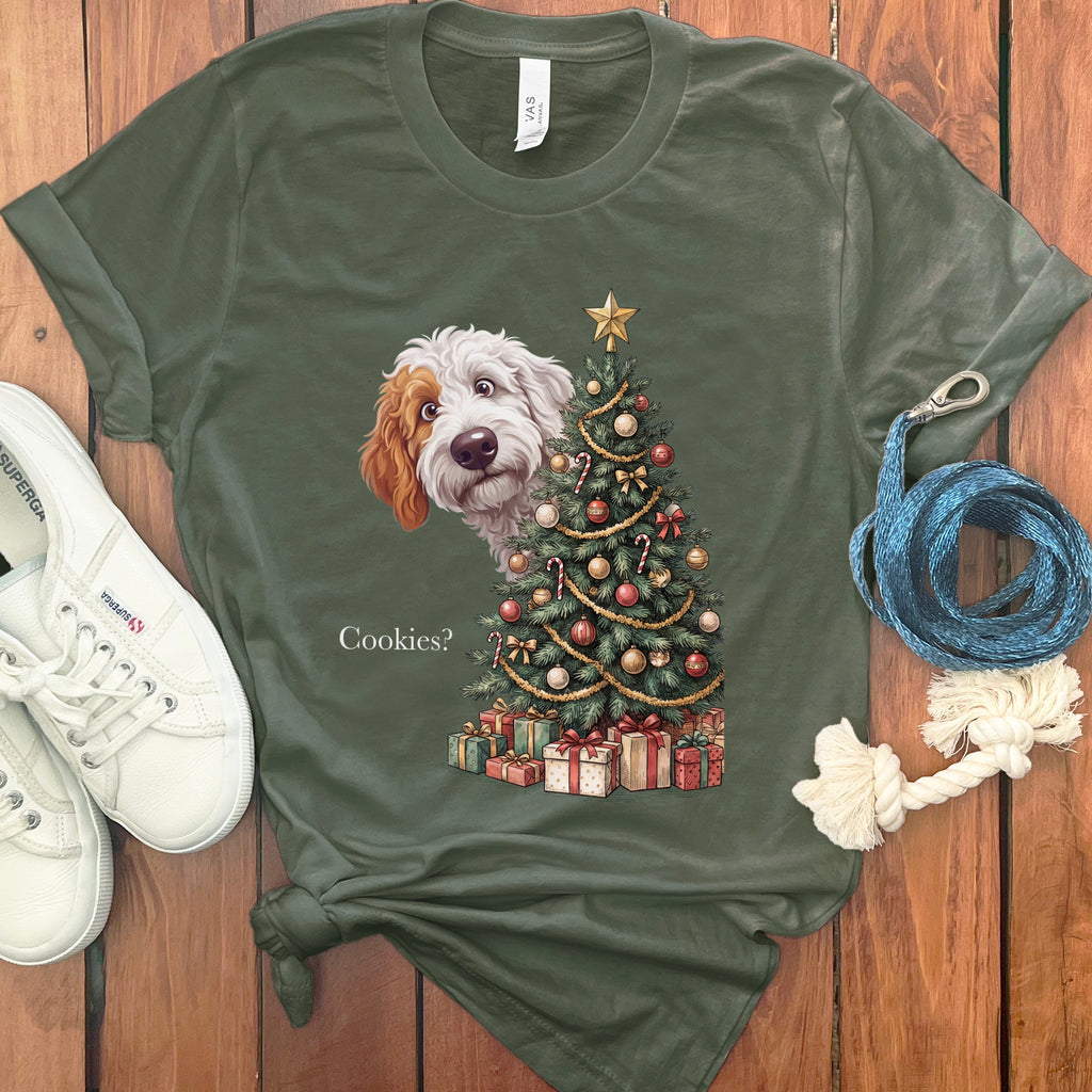Doodle dog peeks from behind a Christmas tree on a green t-shirt that says "Cookies?".