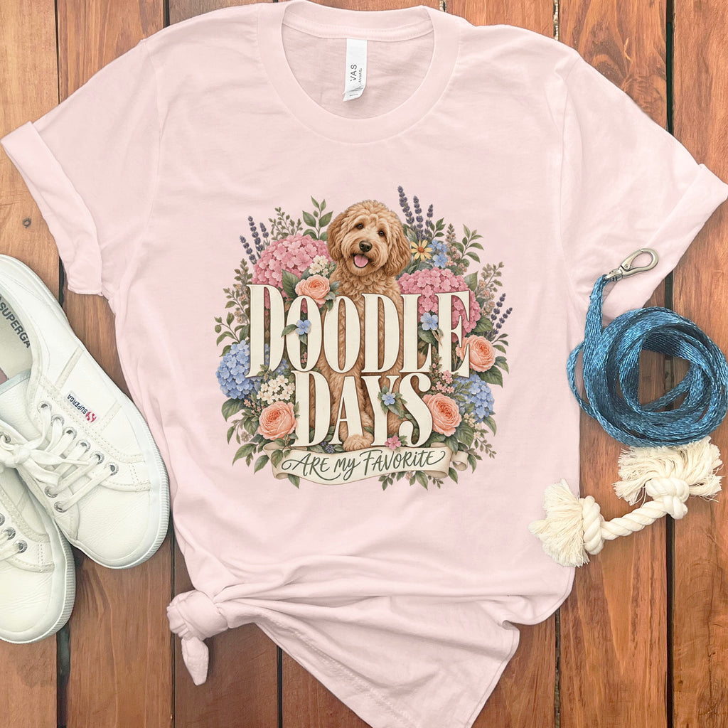 Light pink t-shirt with a doodle dog surrounded by flowers, text reads "Doodle Days Are My Favorite".