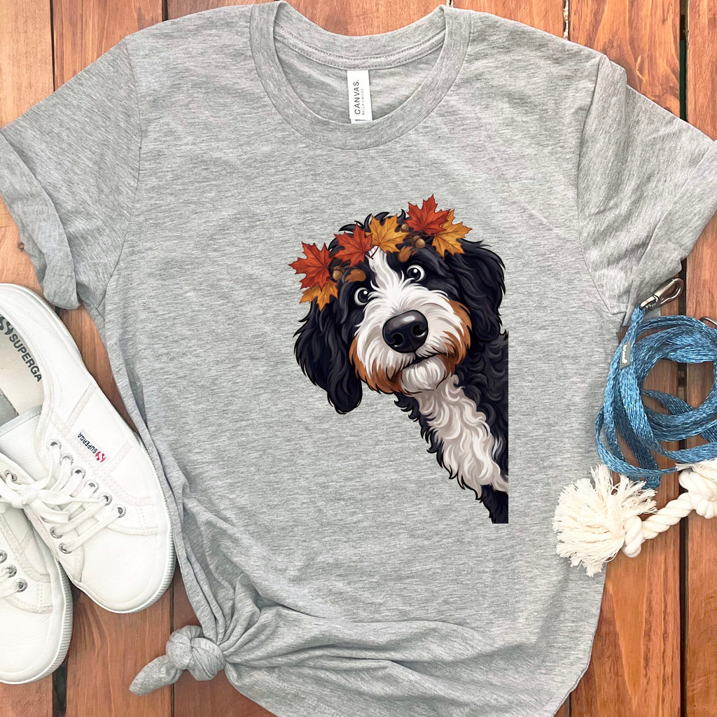 Bernese Mountain Dog wearing a crown of autumn leaves on a grey t-shirt.
