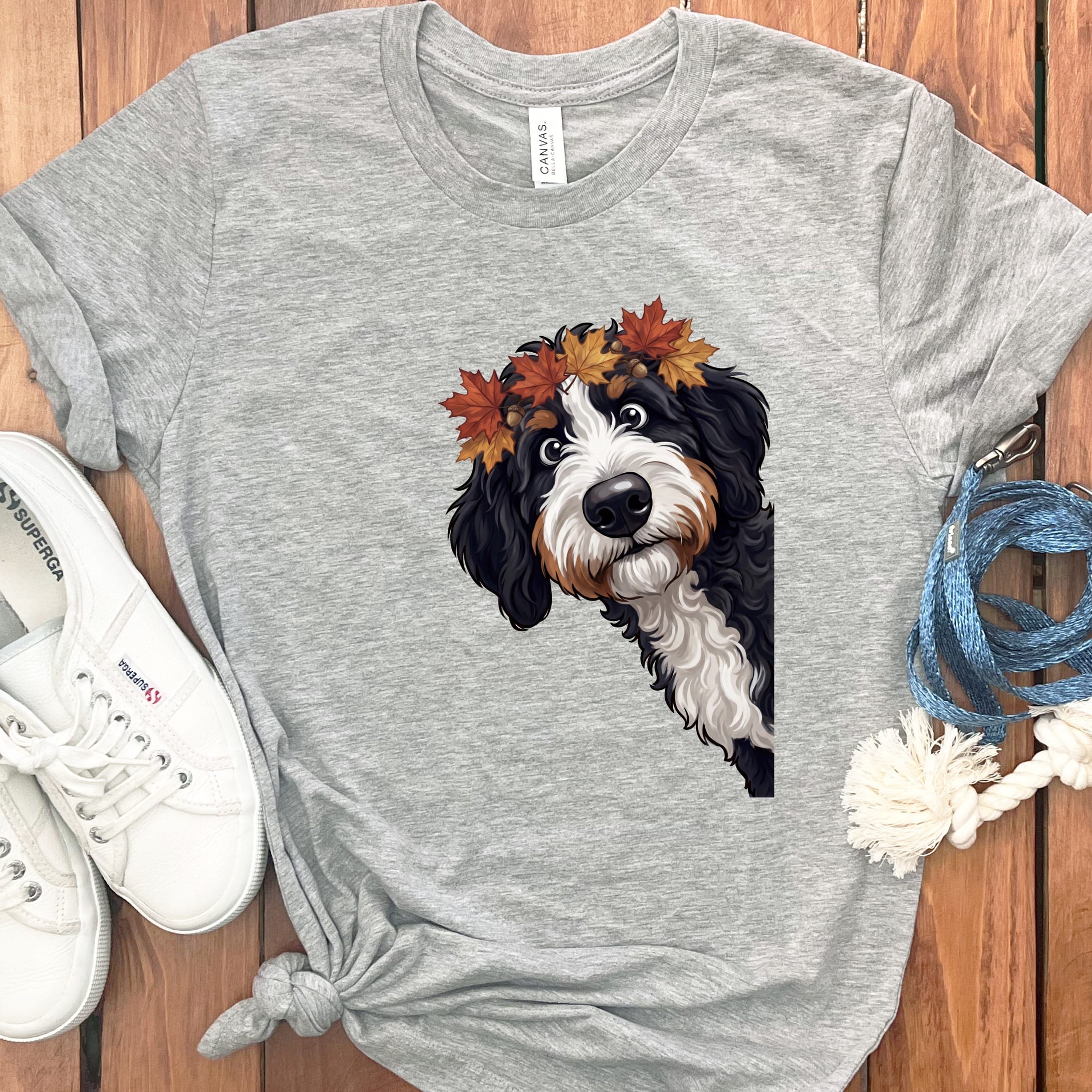 Bernese Mountain Dog wearing a crown of autumn leaves on a grey t-shirt.