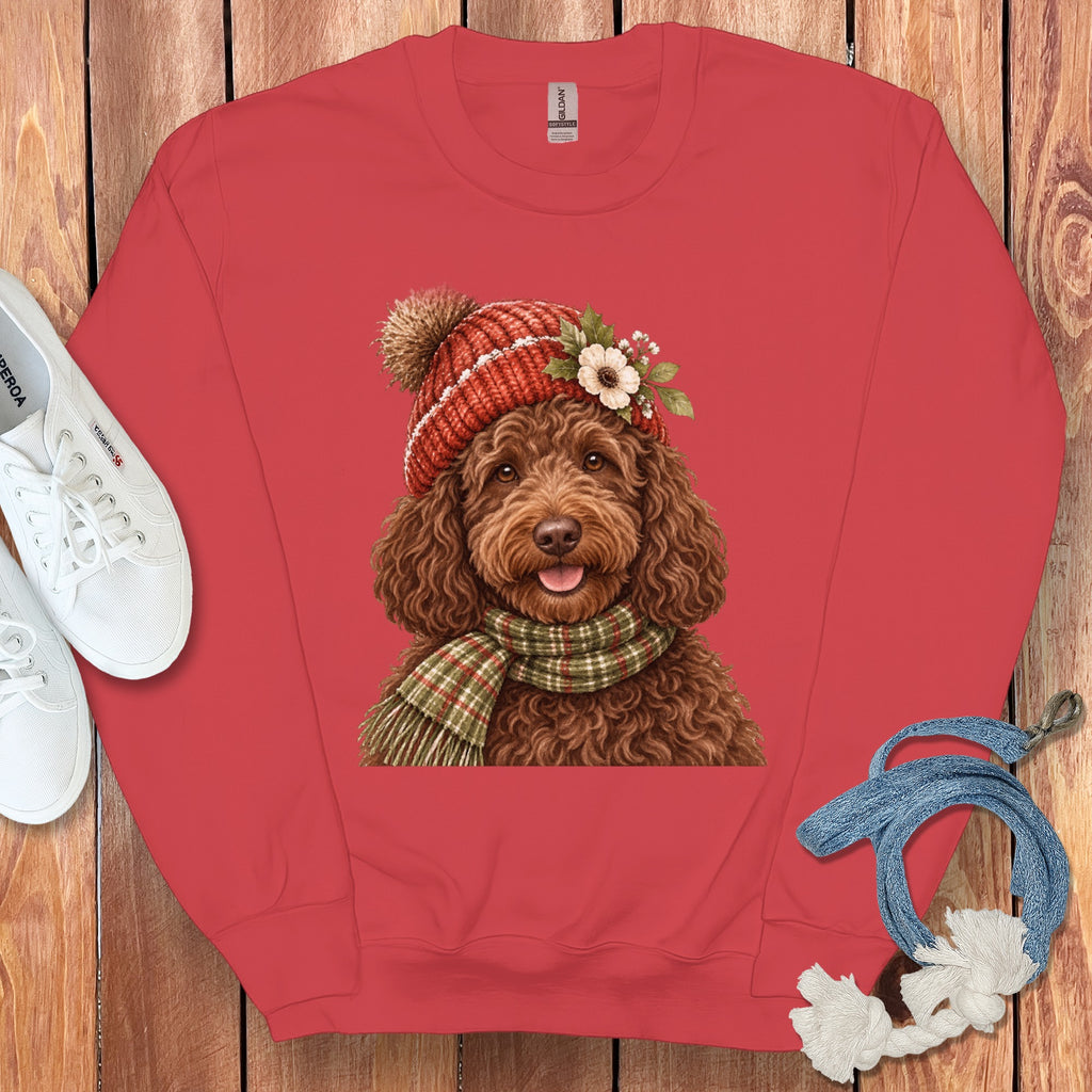 Brown poodle wearing a red knit hat and green plaid scarf with floral accents.