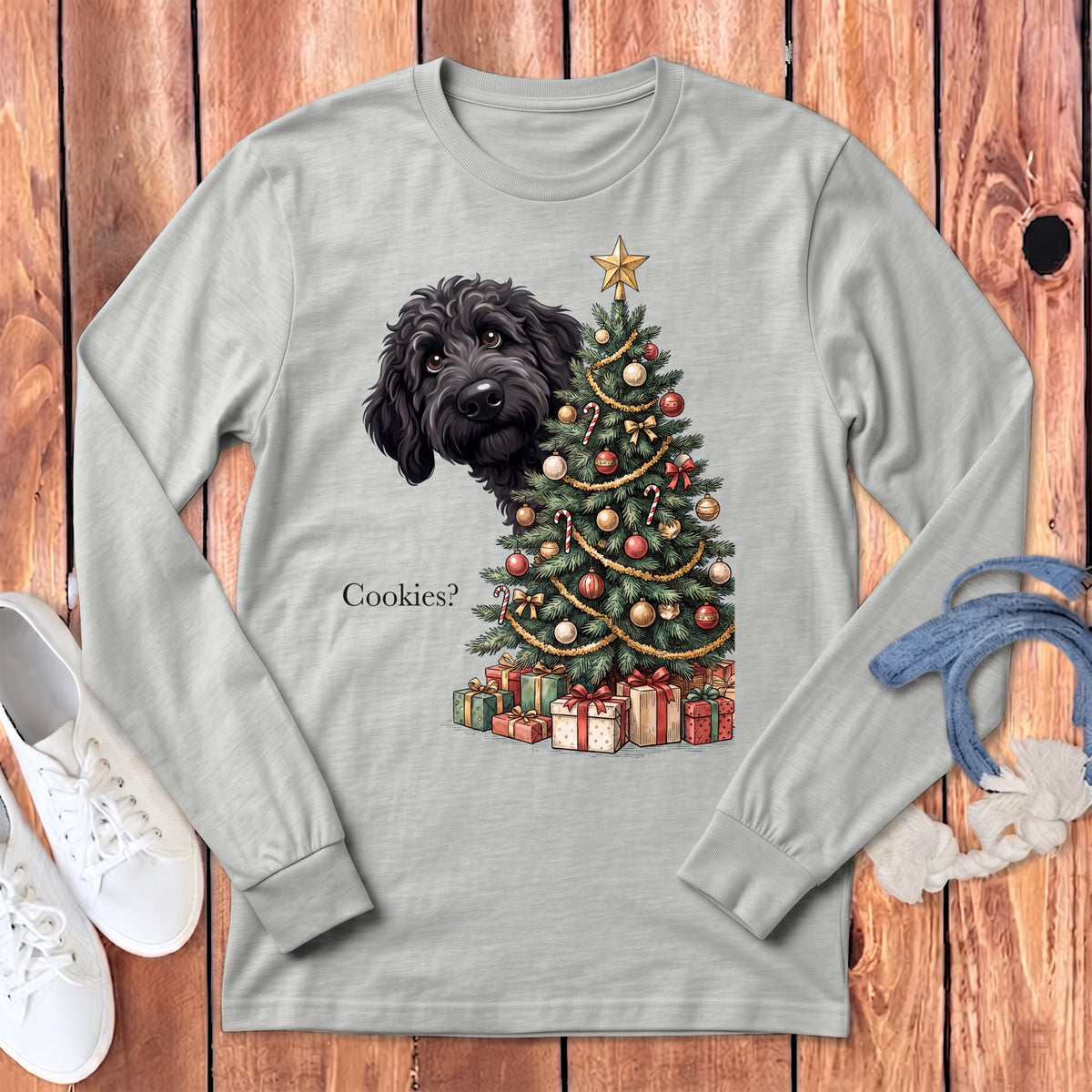 Black doodle dog peeking by Christmas tree with gifts and text "Cookies?".