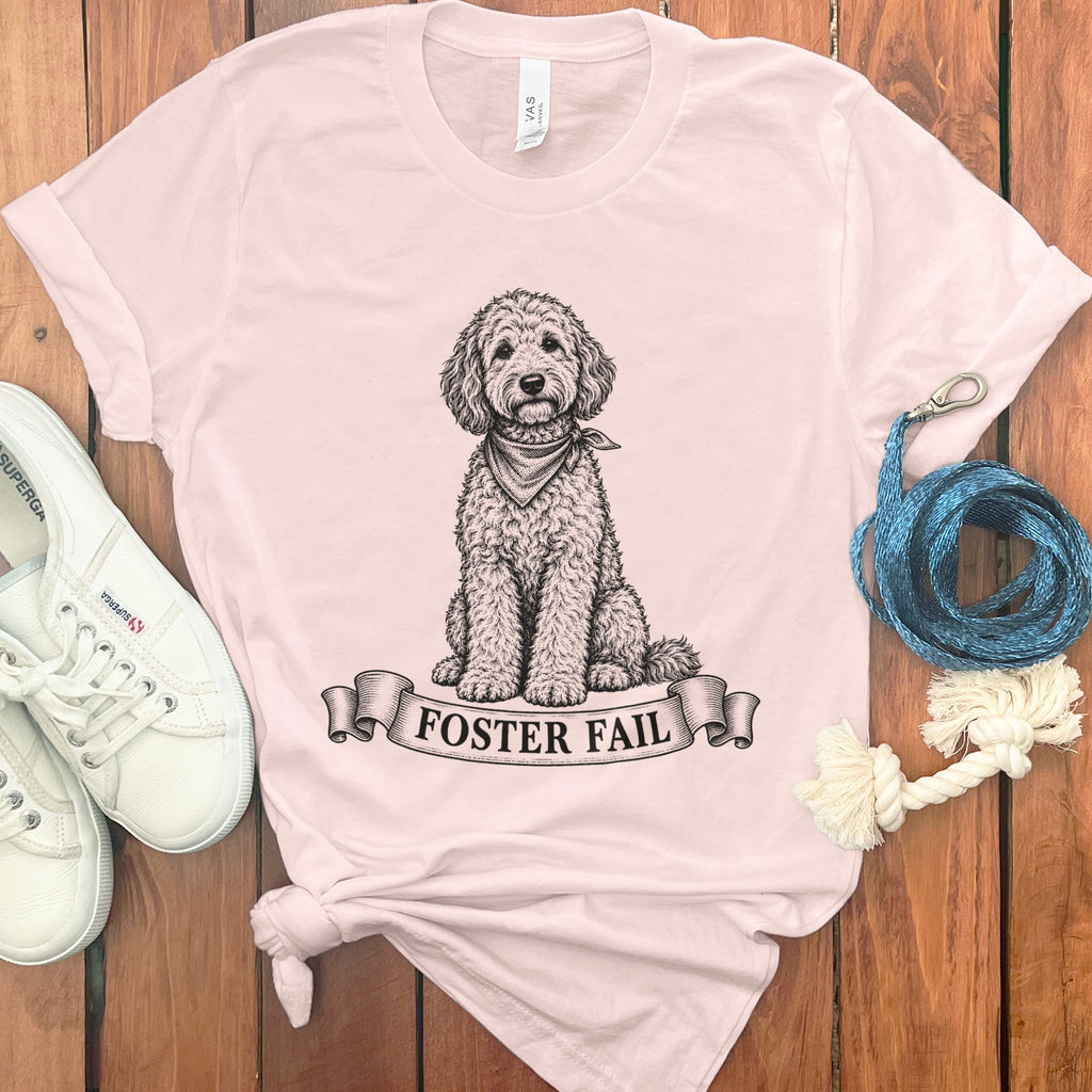Light pink t-shirt with black doodle dog wearing bandana and "FOSTER FAIL" text.