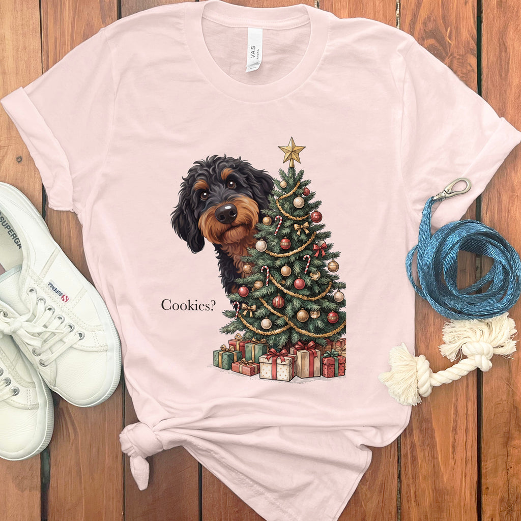 Dachshund peeking from behind a Christmas tree with presents and the text "Cookies?"