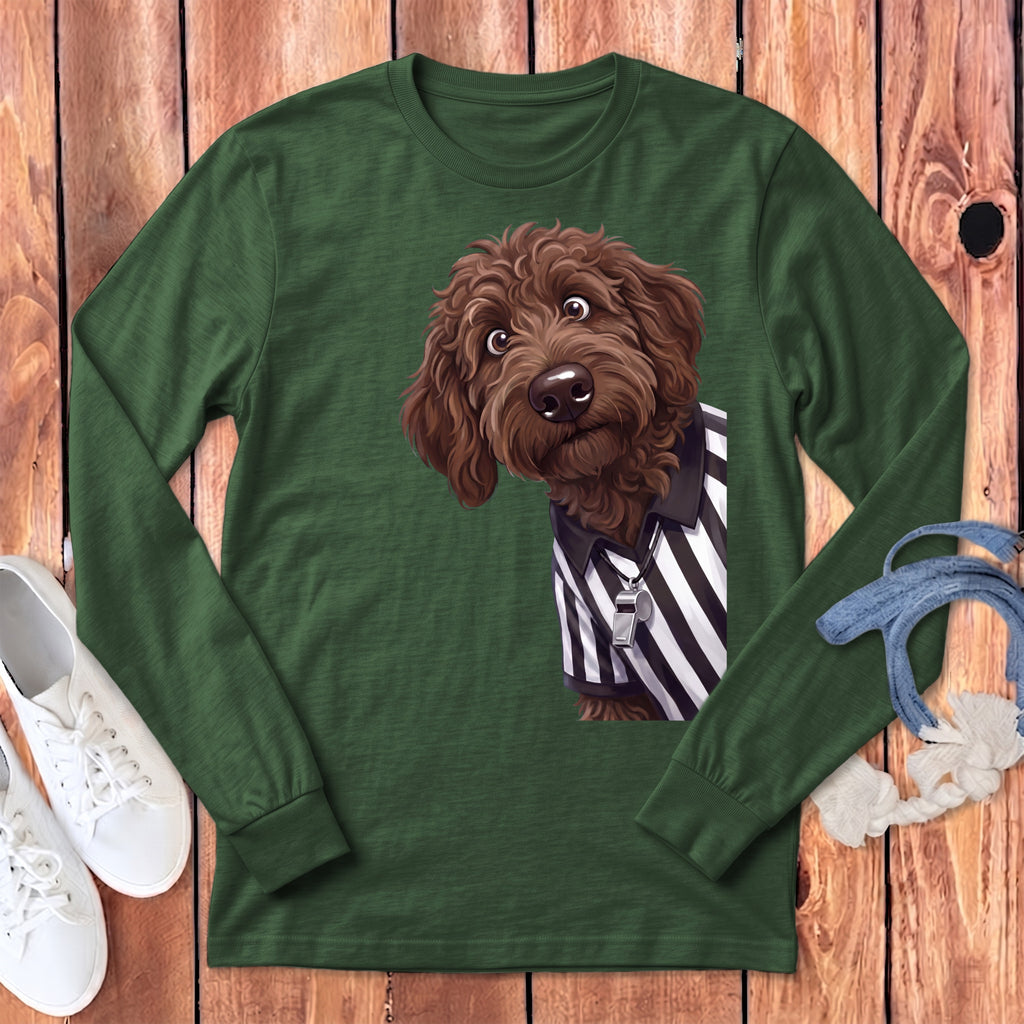 Brown doodle dog wearing a referee shirt with a whistle on a long sleeve green shirt.