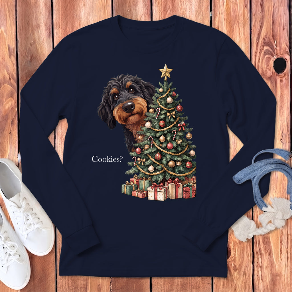 A navy blue long-sleeve t-shirt featuring a black dog peeking behind a decorated Christmas tree with the text "Cookies?".