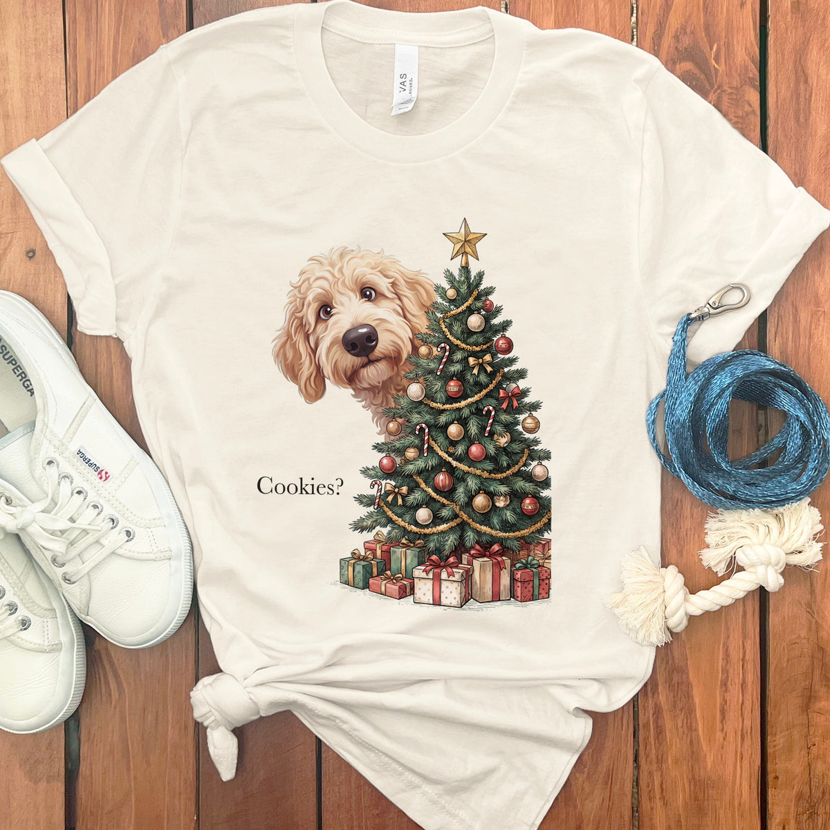 Cream t-shirt with doodle dog peeking behind Christmas tree and gifts, text "Cookies?".