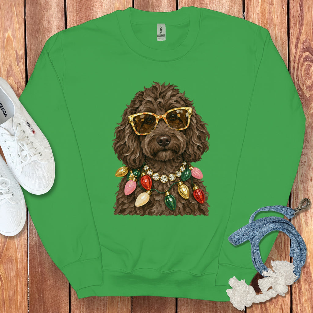 Brown poodle wearing sunglasses and a Christmas light necklace on a green sweatshirt.