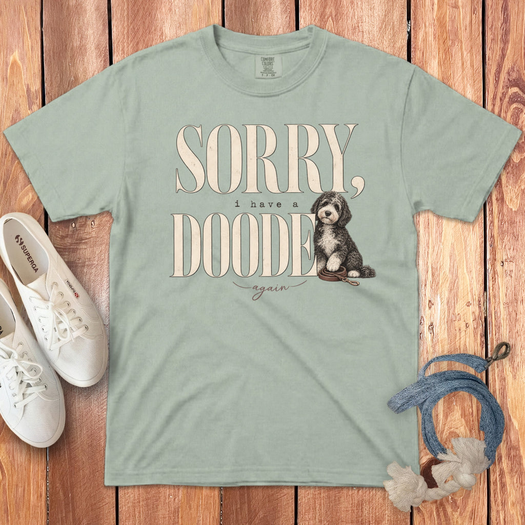 Sage green t-shirt with Sorry I have a doodede again text and a doodle dog graphic.