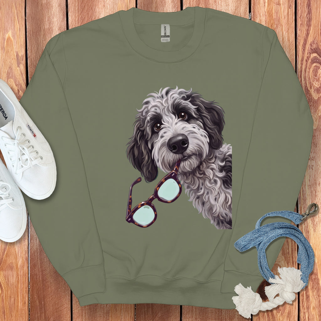 Olive green crewneck sweatshirt featuring a graphic of a fluffy Bernedoodle dog holding tortoise shell glasses.