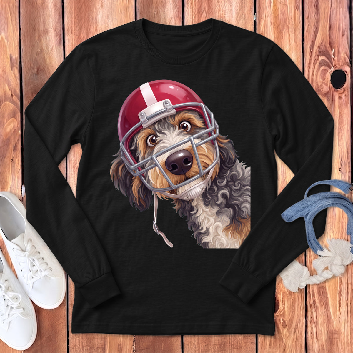 Dog wearing a red football helmet with facemask on a black long-sleeve shirt.