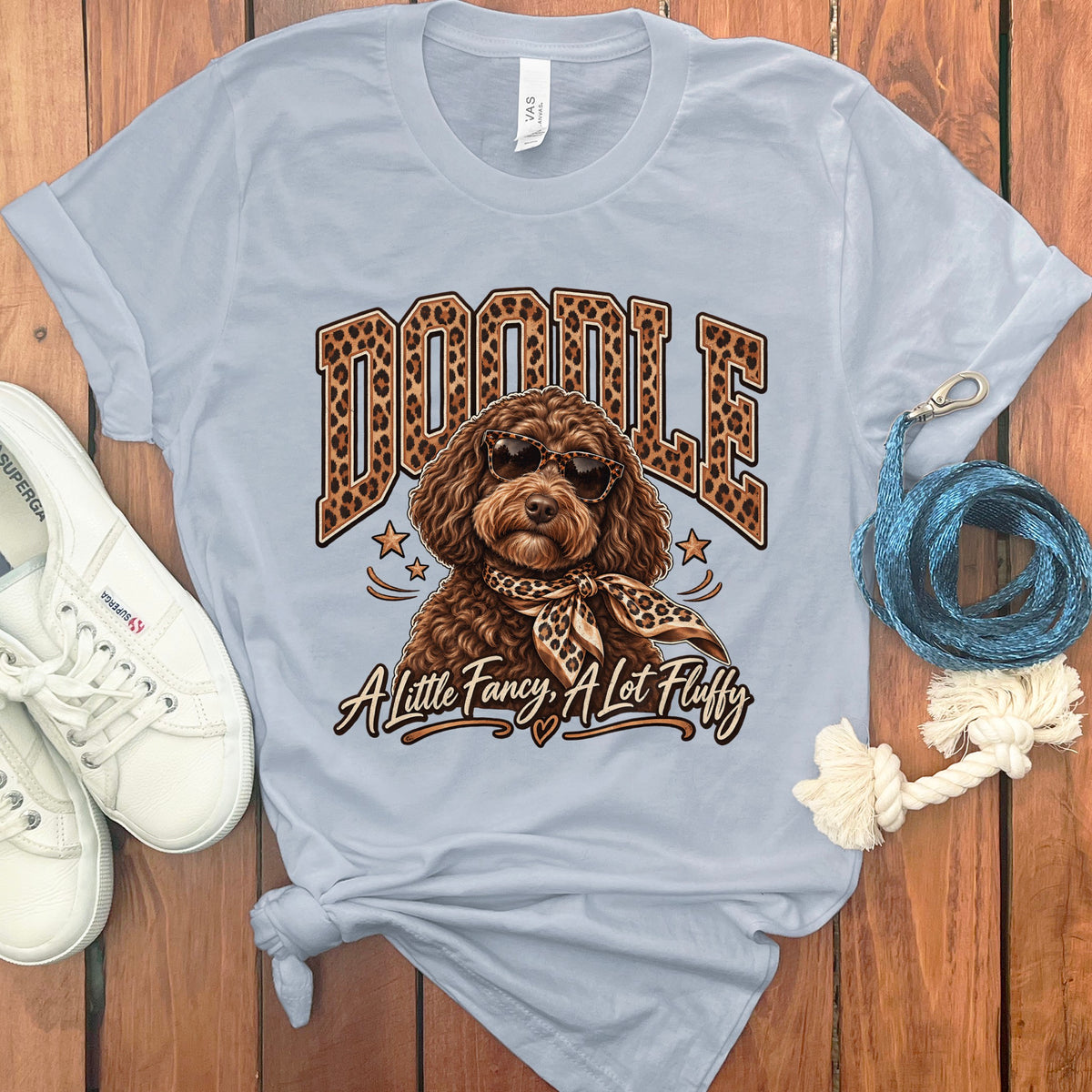 Light blue t-shirt with a doodle wearing sunglasses and bandana, text reads "Doodle A Little Fancy, A Lot Fluffy".