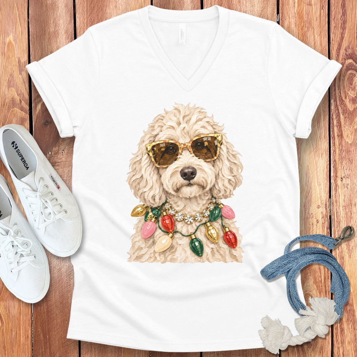 White v-neck t-shirt with a cream-colored dog wearing sunglasses and Christmas lights.