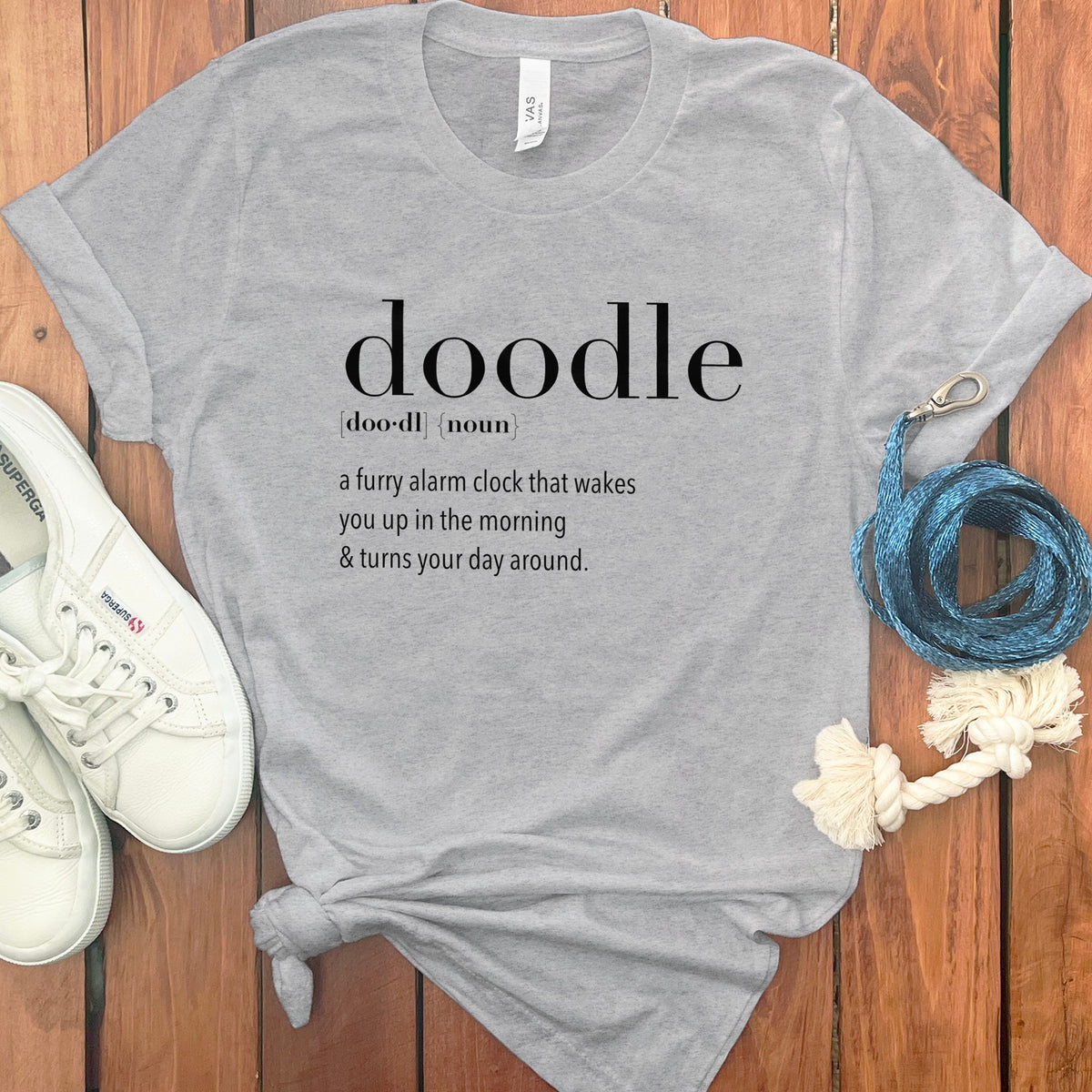 Gray t-shirt with "doodle" definition: a furry alarm clock that wakes you up.