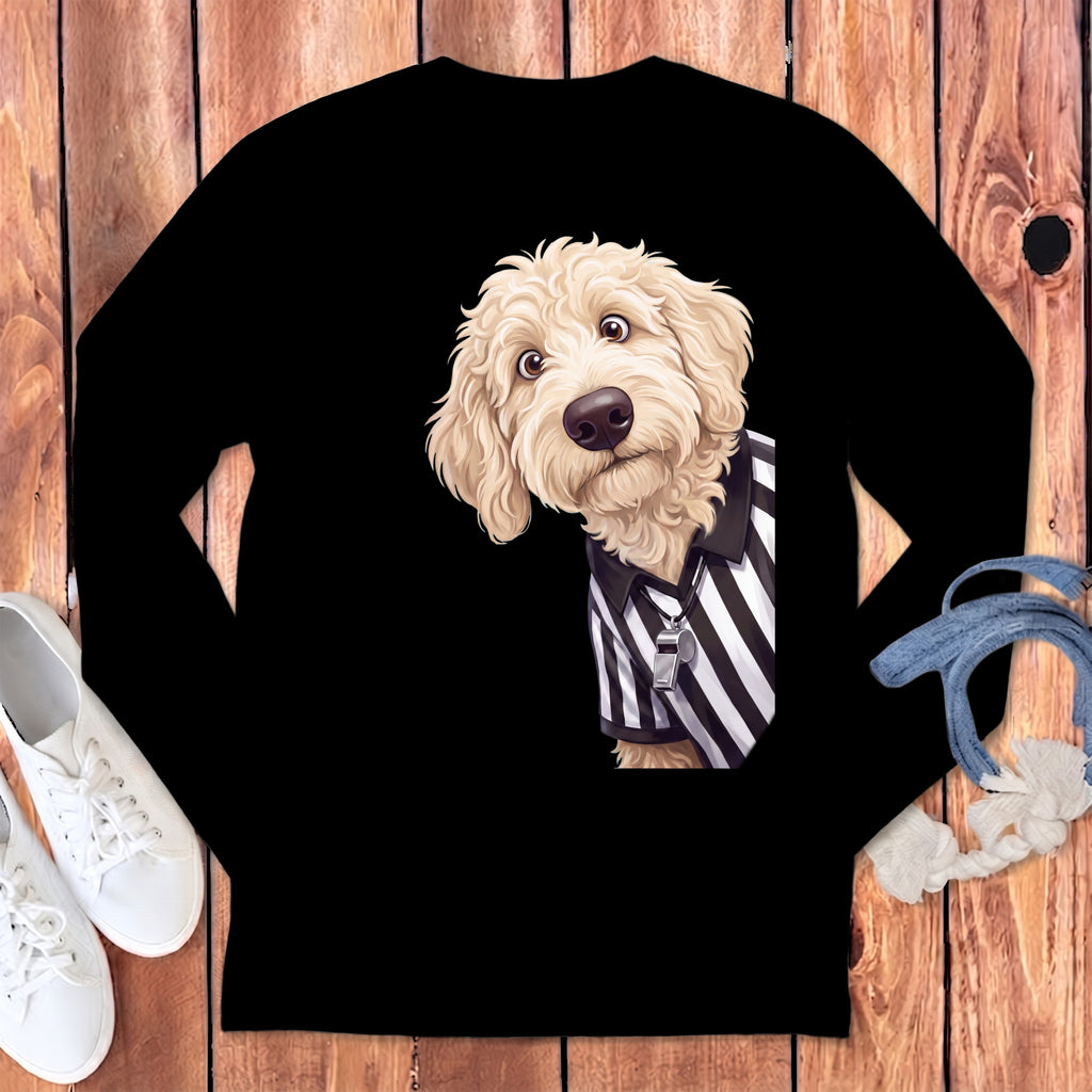 A fluffy dog wearing a black and white striped referee shirt with a whistle.