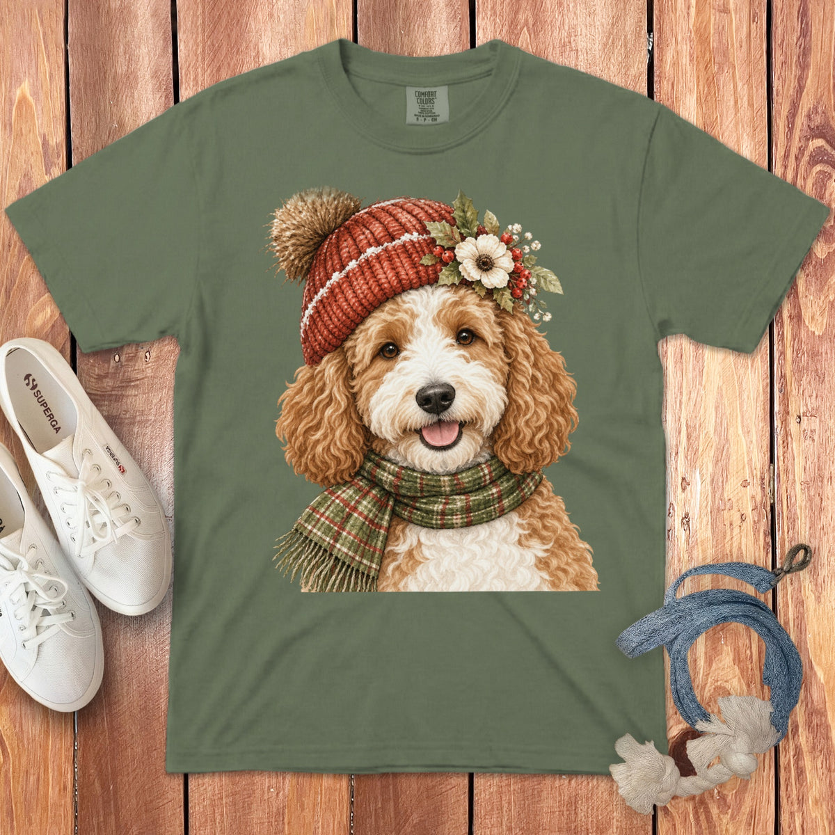 Green t-shirt with watercolor doodle wearing a red knit hat and plaid scarf.