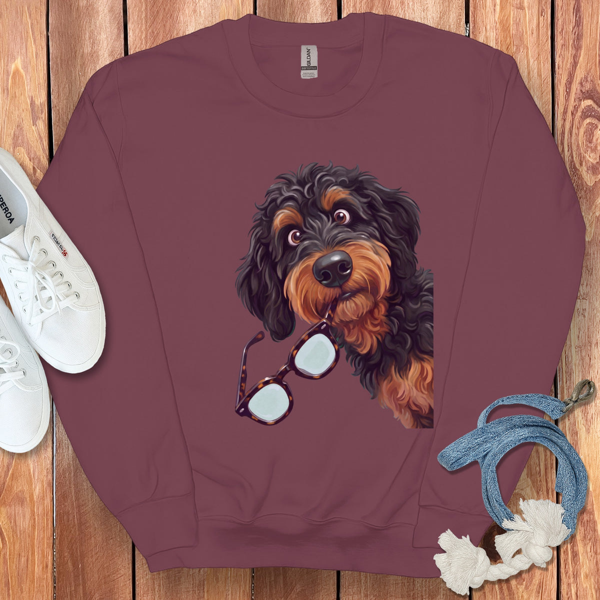 Maroon crewneck sweatshirt featuring a graphic of a black and brown doodle dog holding glasses.