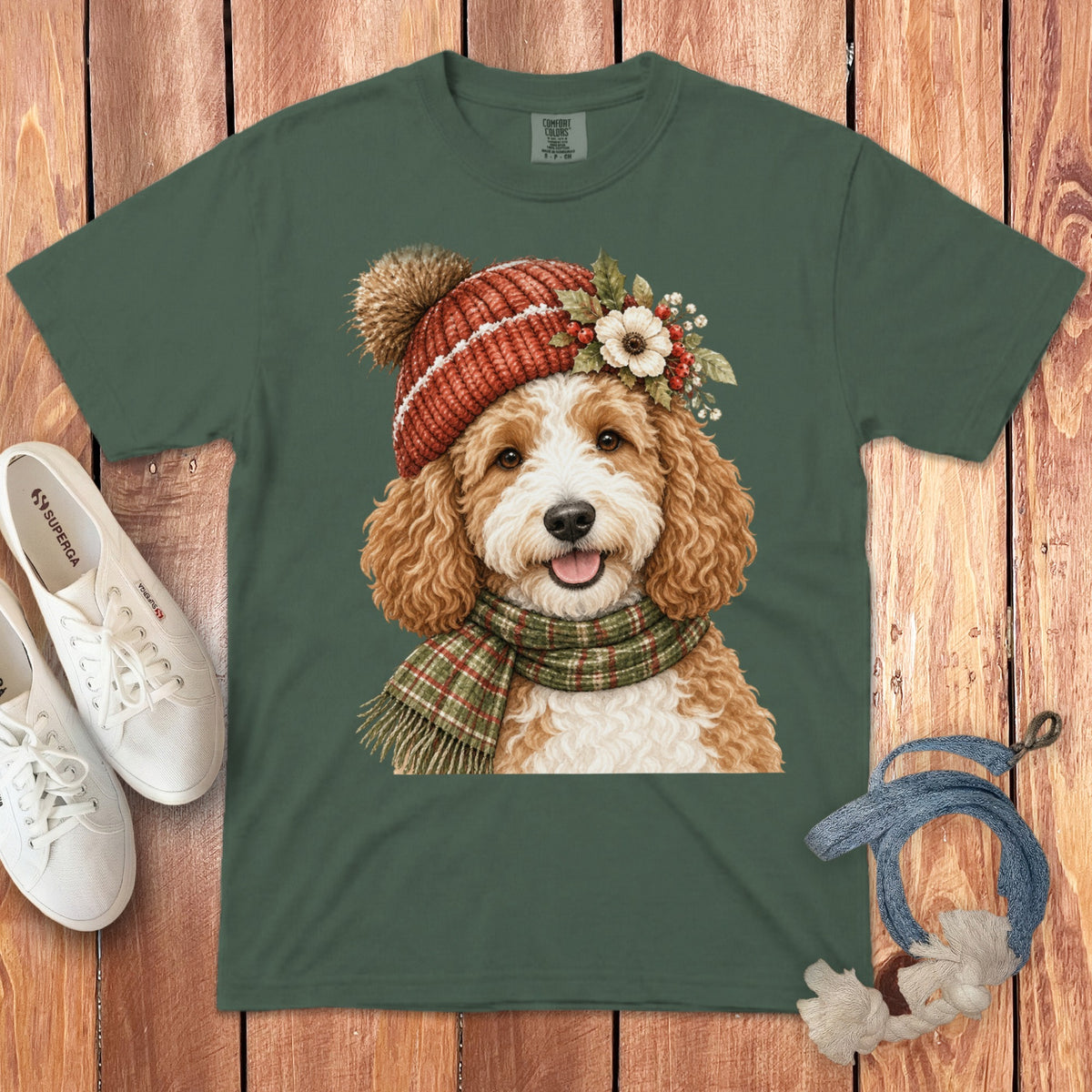 Green t-shirt with a graphic of a happy doodle dog wearing a winter hat and scarf.