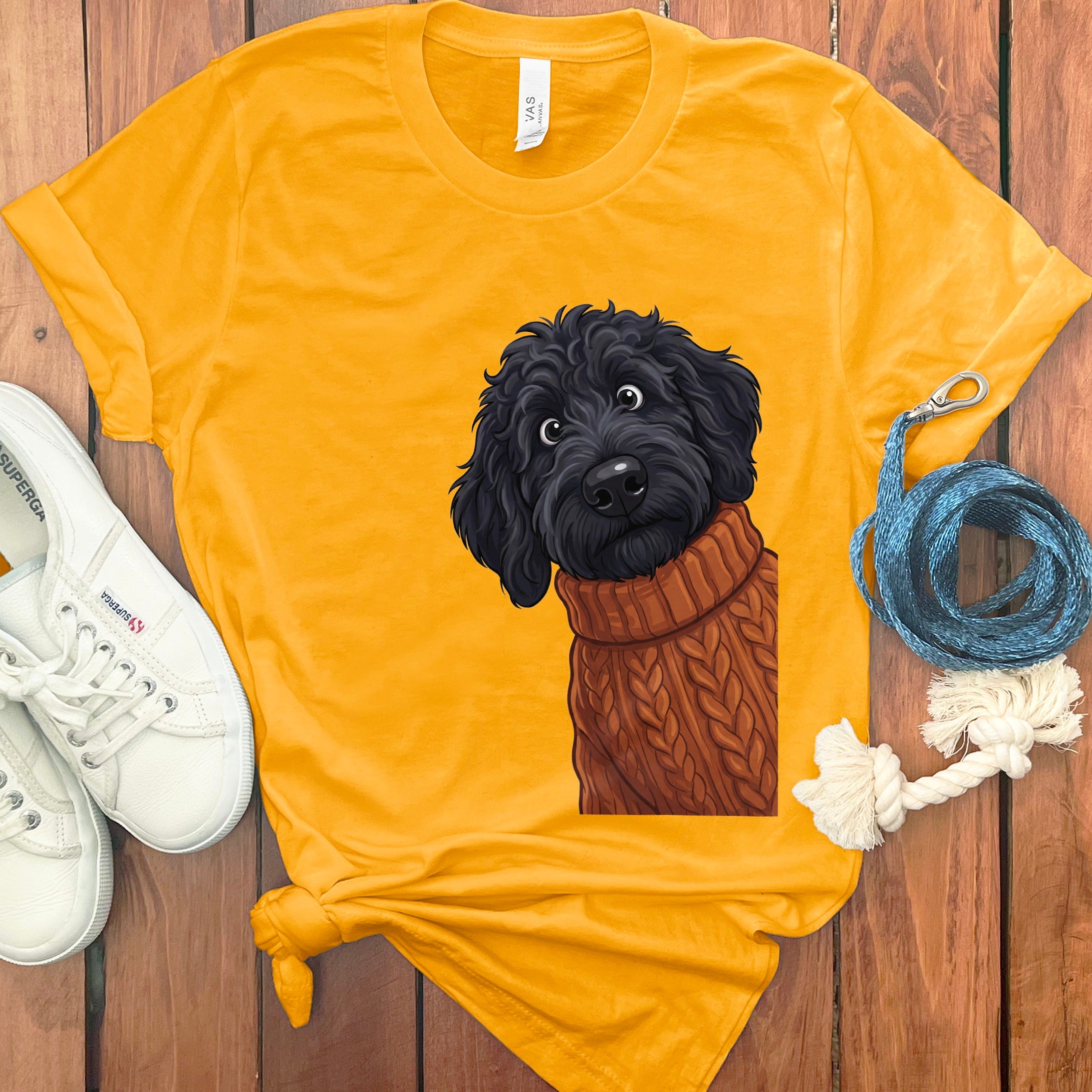 Yellow t-shirt with a black poodle wearing a brown cable knit sweater graphic.