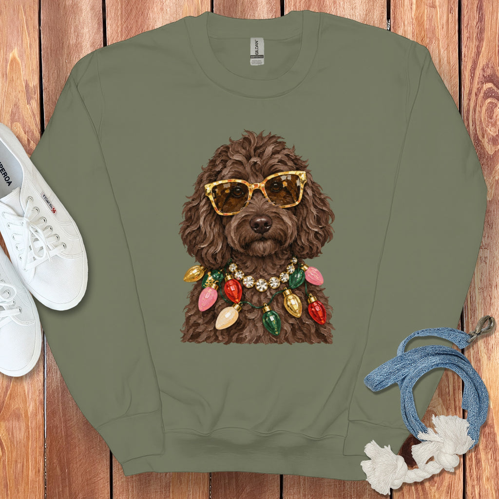 Brown dog wearing sunglasses and a Christmas light necklace on a green sweatshirt.