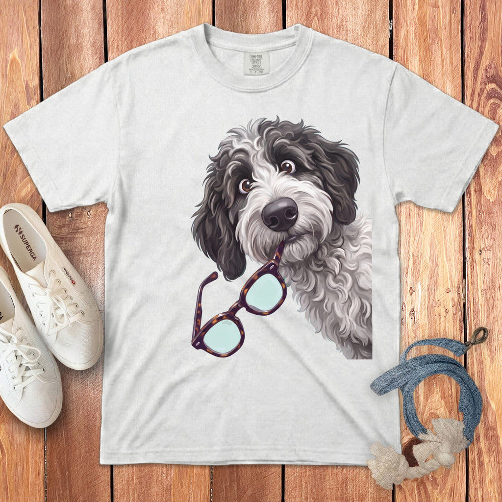 A white crewneck t-shirt featuring an illustration of a black and white dog holding glasses in its mouth.