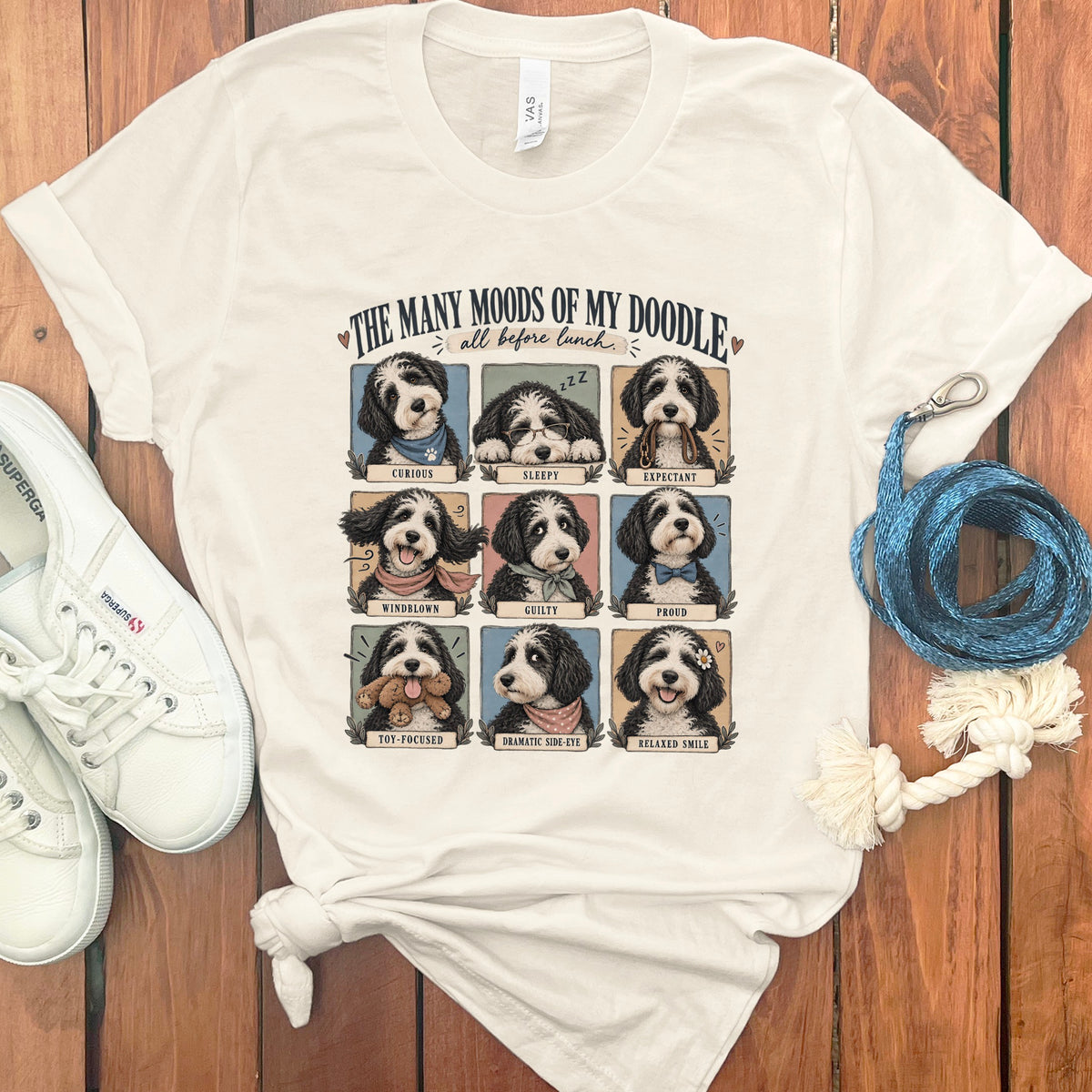 T-shirt with nine panels showing a doodle dog in various moods: Curious, Sleepy, Expectant, Windblown, Guilty, Proud, Toy-Focused, Dramatic Side-Eye, Relaxed Smile.