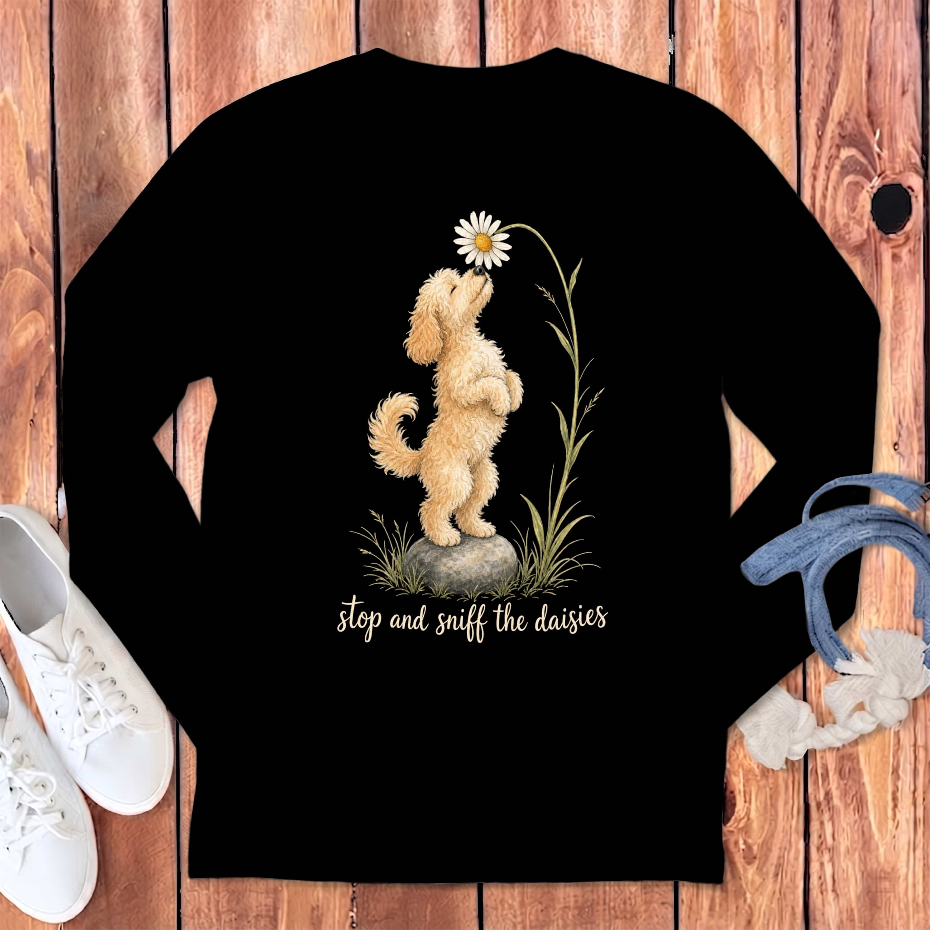 Black long-sleeve shirt with a fluffy dog smelling a daisy, text reads "stop and sniff the daisies".