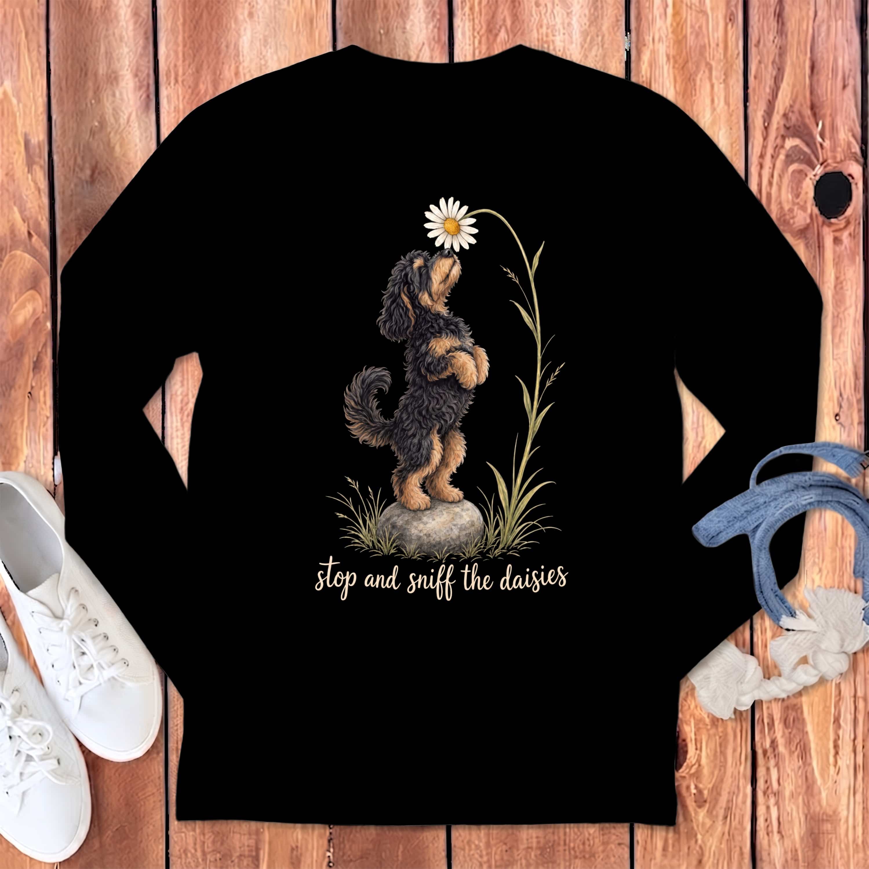 Black long-sleeve shirt with dog smelling a daisy and text "stop and sniff the daisies."