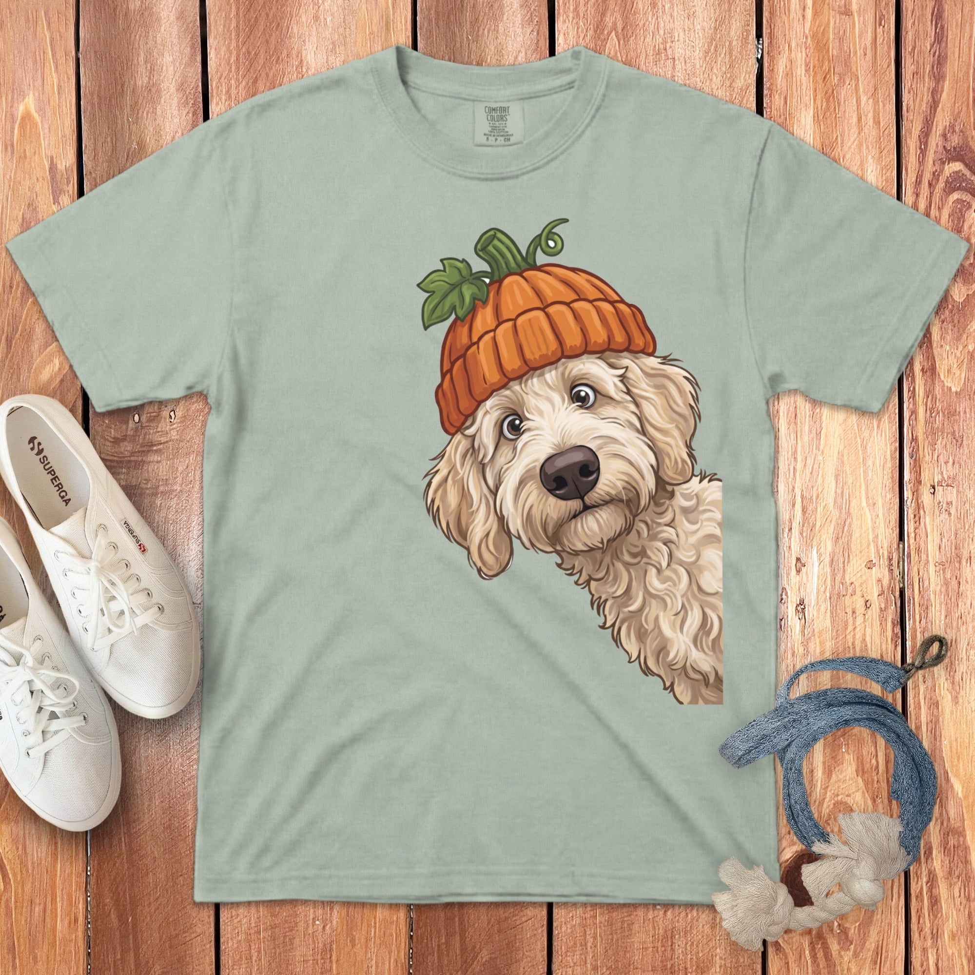 Light green t-shirt with a fluffy dog wearing a pumpkin hat design.