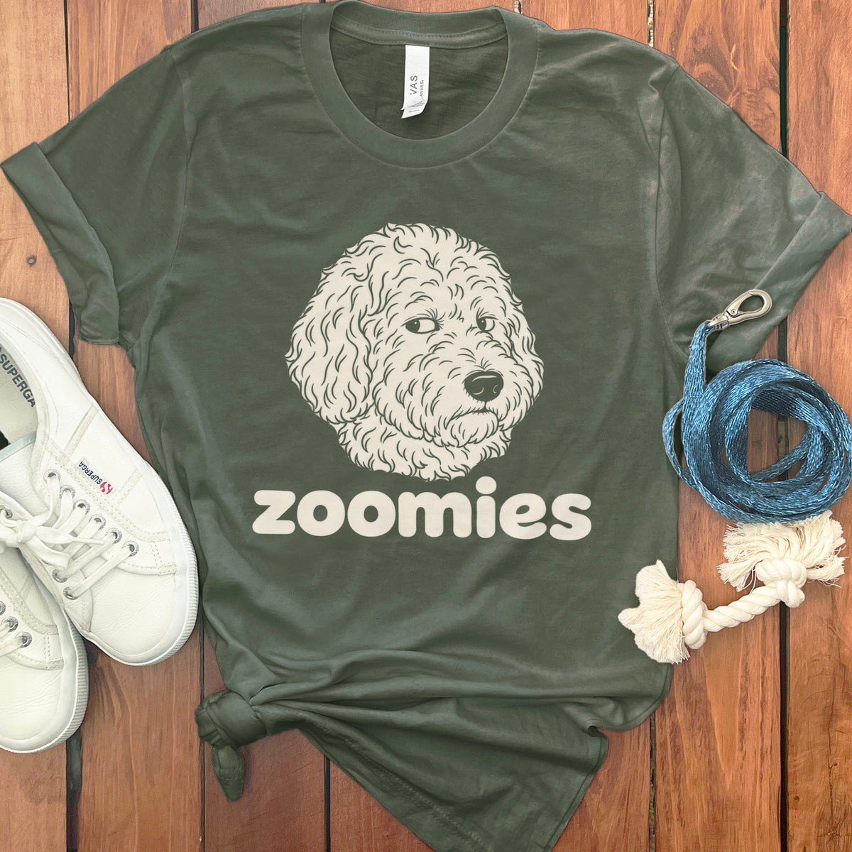Green t-shirt with a doodle dog illustration and the word "zoomies".
