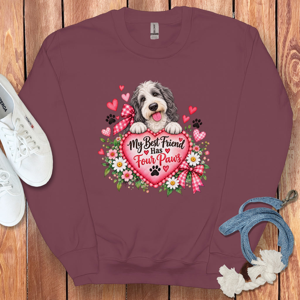Maroon crewneck sweatshirt featuring a graphic of a fluffy dog behind a pink heart with text reading My Best Friend Has Four Paws.