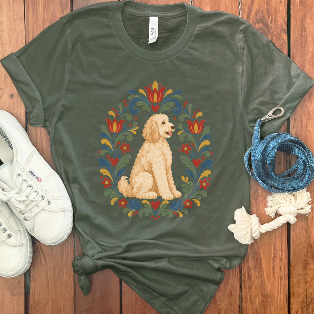 Green t-shirt with a golden doodle in a folk art floral wreath design.