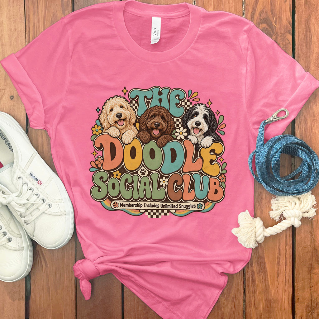 Pink t-shirt with "The Doodle Social Club Membership Includes Unlimited Snuggles" graphic.