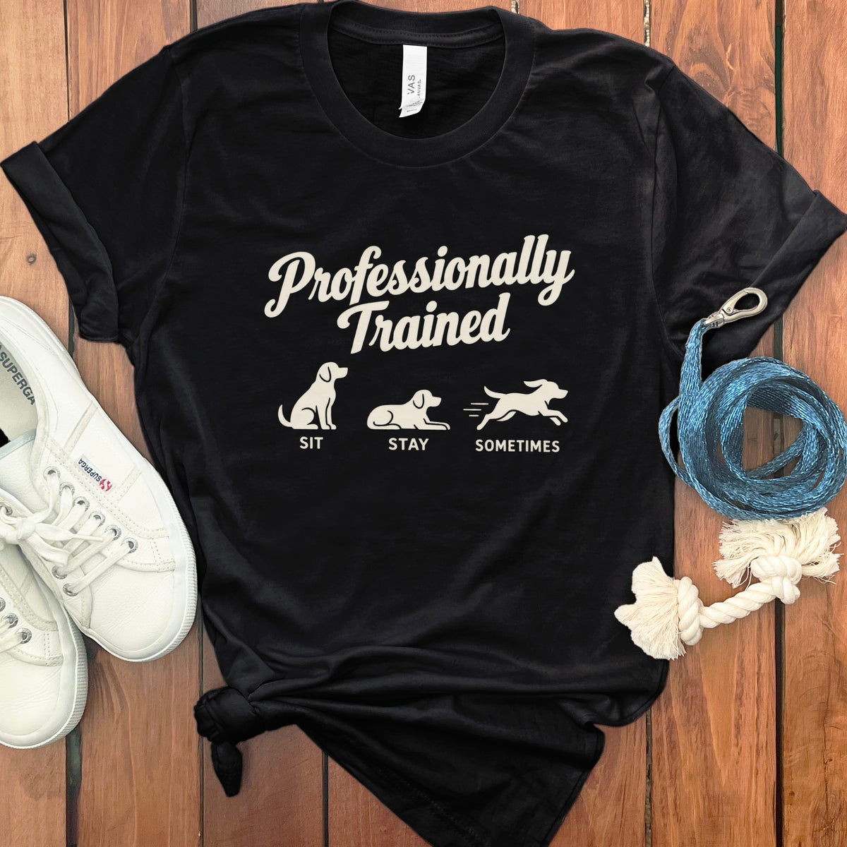 Black t-shirt with "Professionally Trained" text and dog graphics: Sit, Stay, Sometimes.