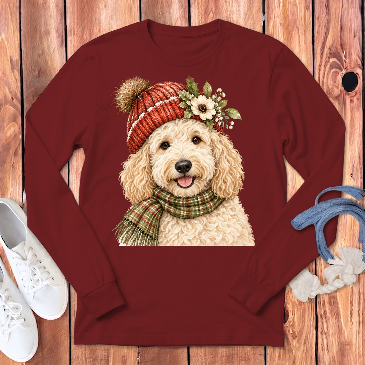 Maroon long-sleeve shirt with a watercolor doodle wearing a festive hat and scarf.
