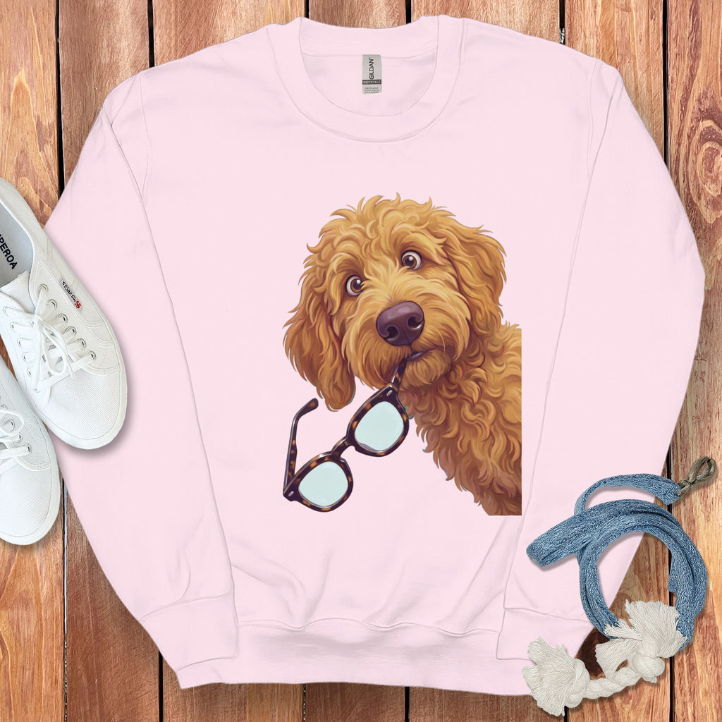 Light pink crewneck sweatshirt with a golden retriever graphic holding tortoise shell glasses in its mouth.