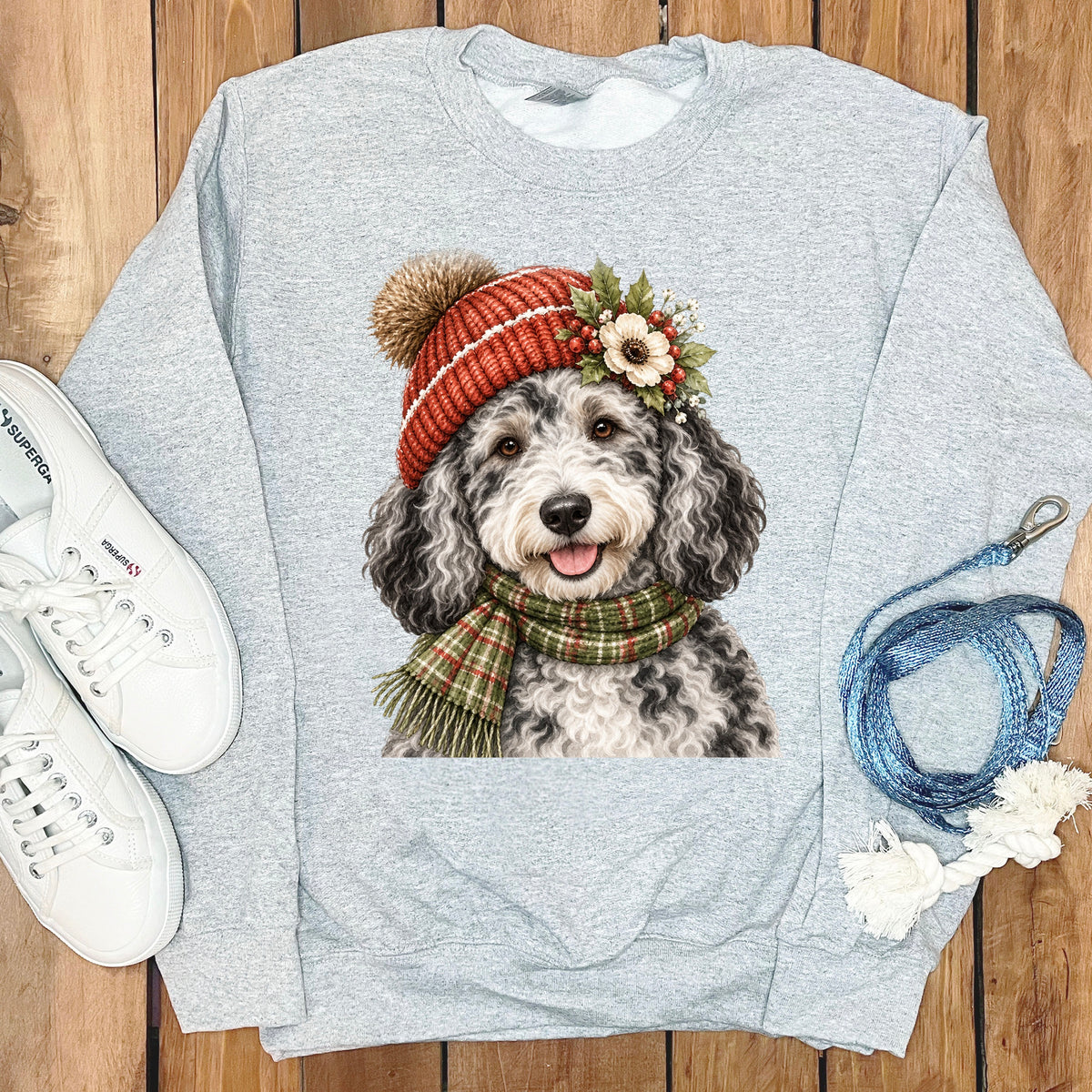 Grey sweatshirt with a watercolor print of a fluffy dog wearing a winter hat and scarf.